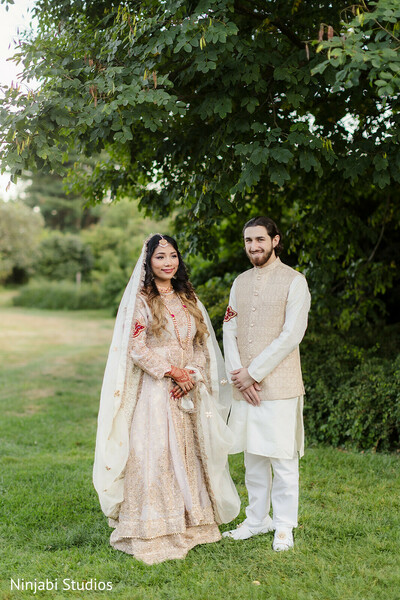 south asian wedding,outdoor wedding,cream lehenga,gold embroidery,sherwani,bridal fashion,groom fashion,wedding portraits,couple photo,traditional attire