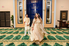Couple in Off-White and Gold Attire on Green Patterned Carpet