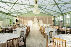 Elegant Greenhouse Venue with Chandeliers and Table Settings