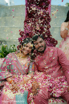 Couple Showered with Pink and White Petals in Front of Floral Installation