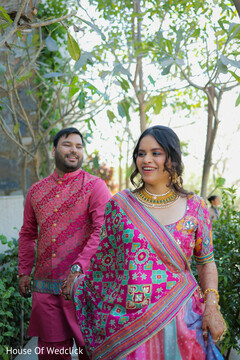 Couple in Vibrant Pink and Blue Attire Holding Hands