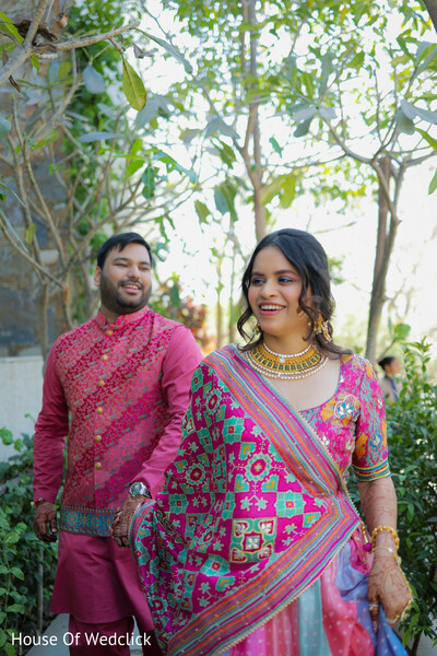 couple portrait,pink lehenga,patterned dupatta,groom fashion,pink kurta,patterned vest