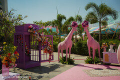 Pink Giraffe Statues with Floral Arrangements and Purple Cage Decor