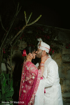 Intimate Nighttime Portrait: Bride in Pink Lehenga & Groom in White Sherwani