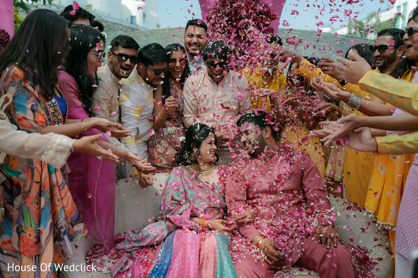 couple,rose petals,celebration,pink petals,colorful attire,festive,joyful,candid,wedding