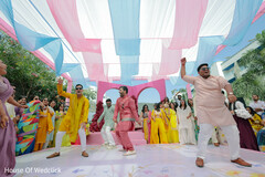 Men Dance in Kurtas Under Pink and Blue Draping