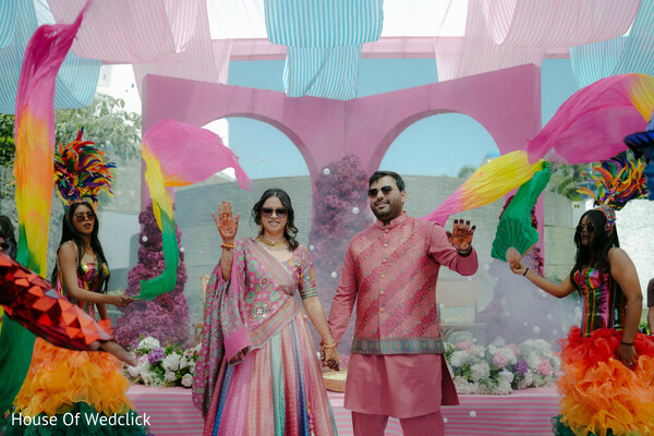 couple,multi-colored lehenga,pink kurta,dancers,colorful fabric,pastel decor,floral arrangements
