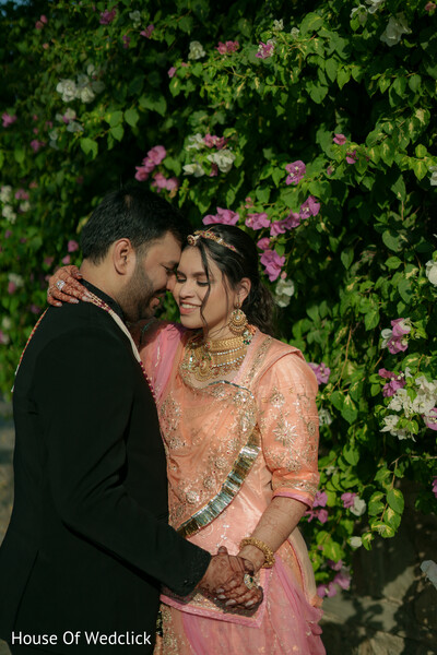 Couple Embraces Amidst Floral Backdrop