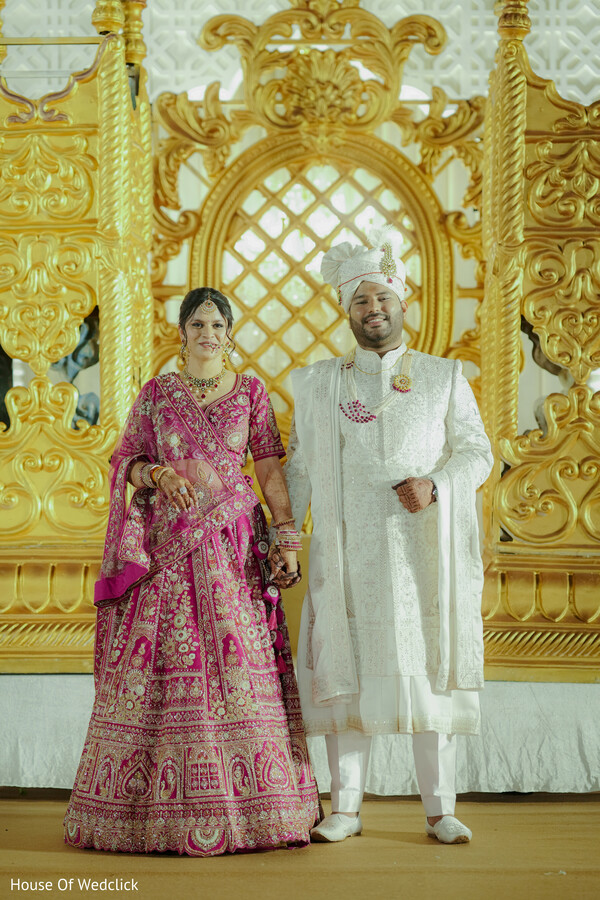 Couple Poses in Front of Gold and White Backdrop