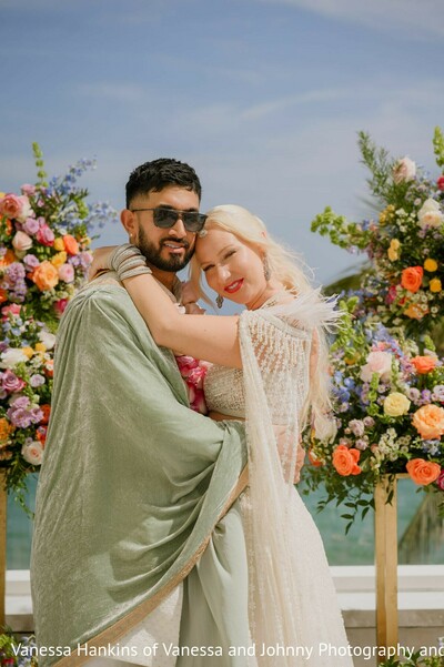 couple portrait,wedding decor,floral arrangements,outdoor wedding,wedding fashion,vibrant flowers,lehenga,green shawl,sherwani
