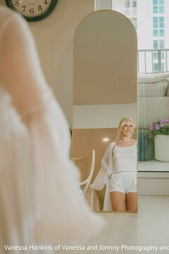 Smiling Bride in White Robe Reflected in Gold Mirror