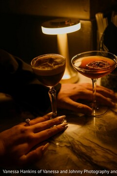 Ring Rests Beside Cocktails Under Warm Lighting
