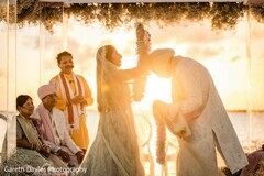 Bride Places Garland on Groom Outdoors