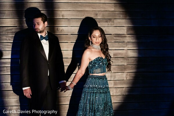 reception fashion,couple portrait,teal lehenga,tuxedo,evening wear,stylish couple,dramatic lighting,south asian wedding,modern reception,formal attire