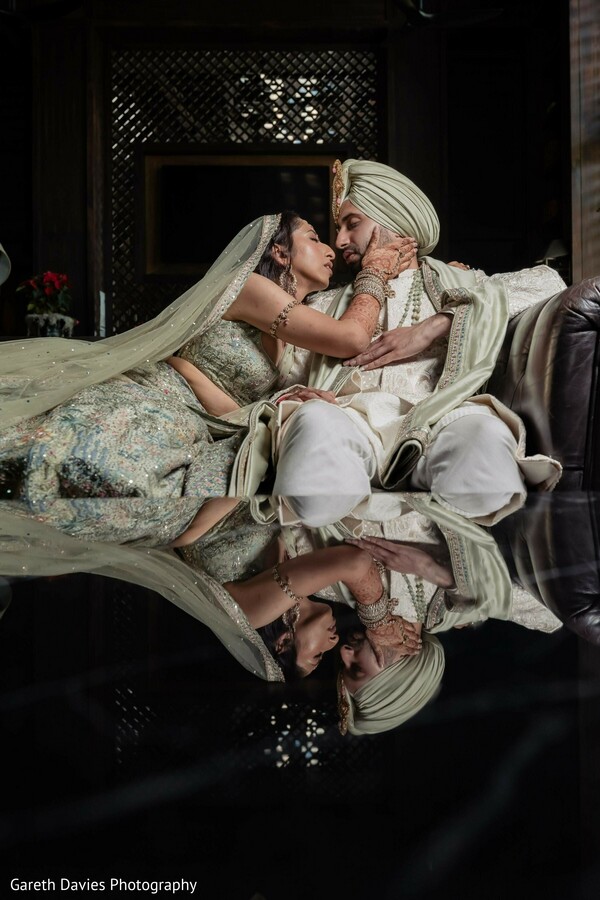 south asian wedding,couple portrait,light green attire,turban,wedding fashion,intimate photo,indoor photo,reflective black floor