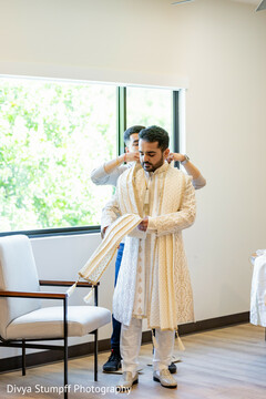 Groom in Intricate White Sherwani and Dupatta Getting Ready