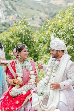 Smiling Couple in Garlands at Outdoor Ceremony