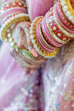 Bride's Hands Adorned with Pink and Red Bangles and Intricate Mehndi