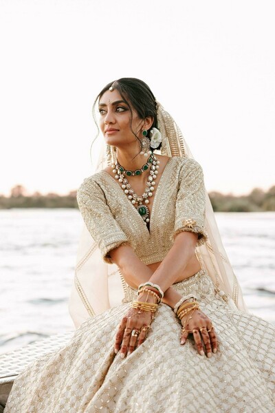 bridal portrait,gold lehenga,green jewelry,pearl necklace,gold embroidery,bangles,bridal mehndi,wedding jewelry,outdoor portrait,elegant bride