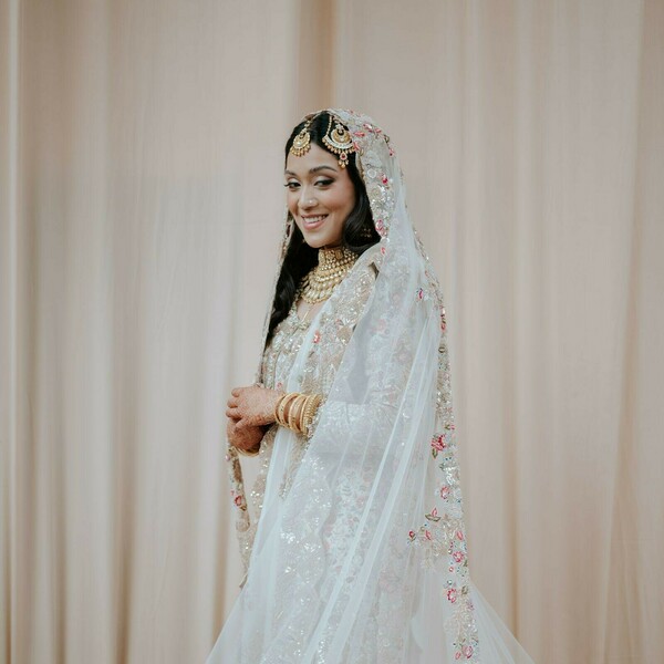 bridal portrait,white lehenga,embroidered lehenga,bridal jewelry,maang tikka,bridal veil,bridal bangles,elegant bride