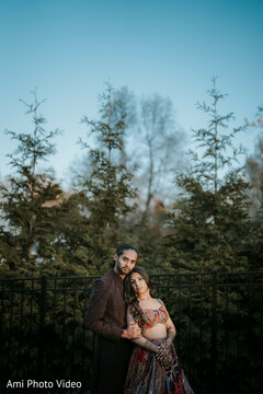 Couple Poses Outdoors with Woman in Patterned Lehenga