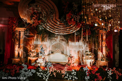 Opulent Red and Gold Stage Decor with Lush Floral Accents