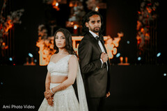 Modern Couple's Elegant Pose in White Lehenga and Tuxedo