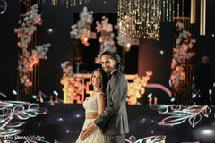 Couple Poses Against a Modern Floral and Light Display Backdrop