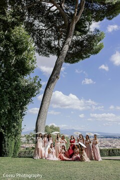 Bridal Party Posing with Parasols Against a Scenic Hillside Backdrop