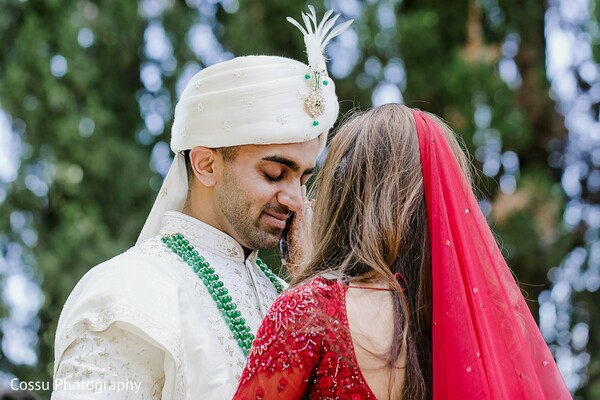 groom,bride,green necklace,red veil,outdoor,couple,cream attire,turban