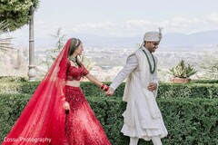 Vibrant Red Lehenga and White Sherwani for a Scenic Outdoor Photo Session