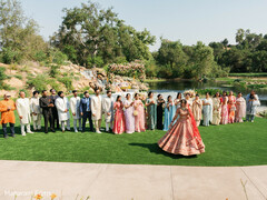 Vibrant Bride in Red Lehenga with Bridal Party by Lakeside Waterfall