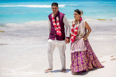Indian bride and groom walking by the ocean in their ceremony Indian bride and groom walking by the ocean in their ceremony