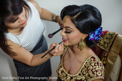 Make up artist giving the final touches to indian bride's make up Make up artist giving the final touches to indian bride's make up