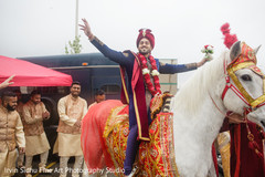 Indian groom riding a white horse during baraat procession. Indian groom riding a white horse during baraat procession.