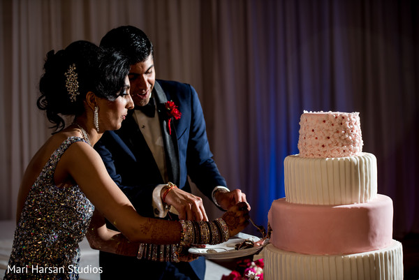 Indian bride and groom cutting their wedding cake.