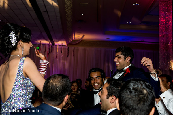 Bride and groom carried by the guests at their wedding reception.