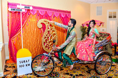 Indian bride and groom entering into their garba in a rickshaw. Indian bride and groom entering into their garba in a rickshaw.