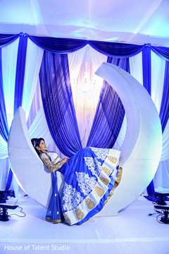 Fantastic shot of indian bride posing in a beautiful white moon. indian bride,indian wedding photography session,indian wedding reception decor