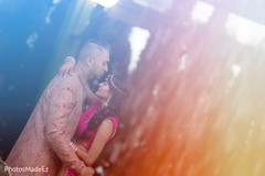 Indian bride and groom at their sangeet celebration in pink outfits. Indian bride and groom at their sangeet celebration in pink outfits.