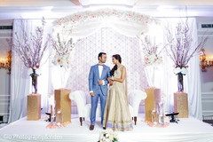 Indian bride and groom posing on their reception stage. Indian bride and groom posing on their reception stage.