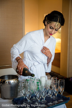 Beautiful indian bride serving champagne while getting ready. Beautiful indian bride serving champagne while getting ready.