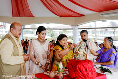Indian bride with her parents during a pre-wedding ritual. Indian bride with her parents during a pre-wedding ritual.