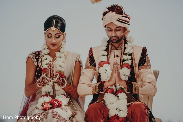 Beautiful capture of Indian bride and groom praying.