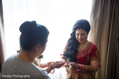 Charming indian bride getting help with her bangles. Charming indian bride getting help with her bangles.