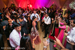 Indian couple dancing along all the wedding guests. Indian couple dancing along all the wedding guests.