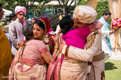 Indian couple hugging their mothers at wedding ceremony Indian couple hugging their mothers at wedding ceremony