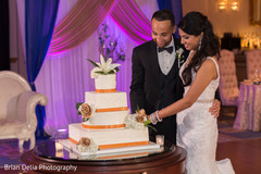 Indian couple cutting the cake at wedding reception Indian couple cutting the cake at wedding reception