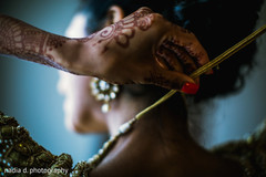 Bride adjusting her jewelry. indian bride,indian bride getting ready,indian wedding mehndi