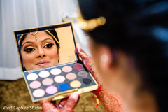 Indian bide taking a final look to her makeup. Indian bide taking a final look to her makeup.